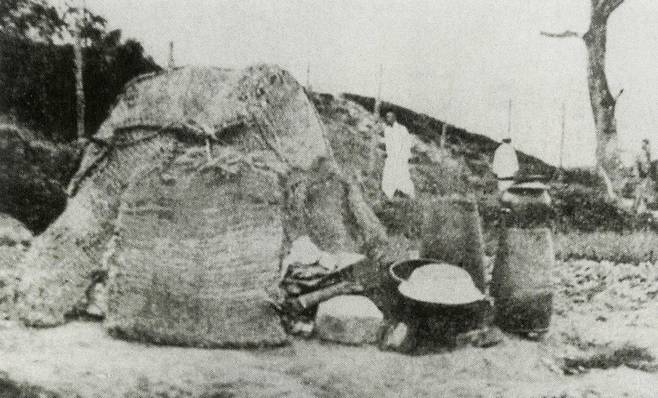 일제강점기 일자리를 찾아 농촌에서 서울로 올라온 사람들은 산기슭이나 하천변 등에 임시로 지은 토막에서 비참하게 지내야 했다. 가마니로 둘러친 토막의 모습. <일제 침략 아래에서의 서울>