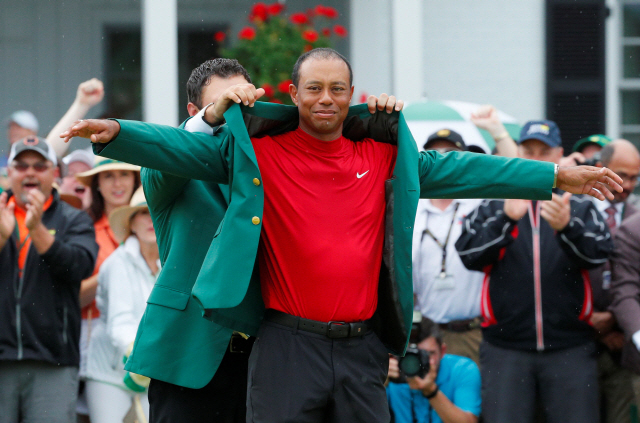 Golf - Masters - Augusta National Golf Club - Augusta, Georgia, U.S. - April 14, 2019 - Patrick Reed places the green jacket on Tiger Woods of the U.S. after Woods won the 2019 Masters. REUTERS/Brian Snyder TPX IMAGES OF THE DAY        <저작권자(c) 연합뉴스, 무단 전재-재배포 금지>