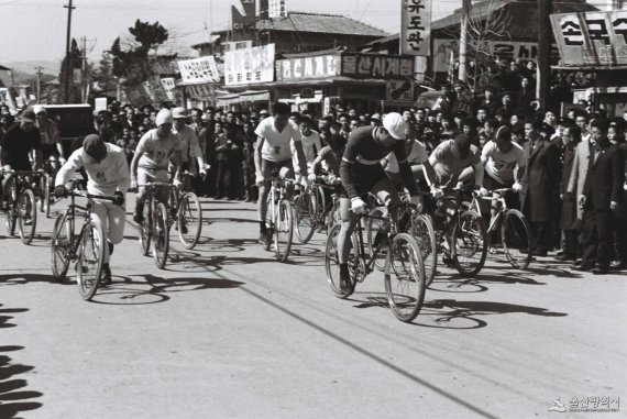 1965년 울산에서 열린 3.1절 기념 도로 사이클 대회 모습. 울산시내 중심부에서 출전 선수들이 출발하고 있다. 수많은 울산시민들이 관심 있게 지켜보고 있다. 출전 선수 상당수가 사이클용 모자를 쓰고 있는 것이 예전과 다른 모습이다. /사진=울산시 제공
