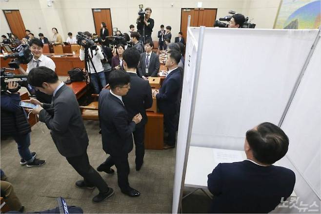 29일 밤 시작된 정치개혁특별위원회 전체회의가 자정을 넘겨 종료됐다. 이날 김재원 자유한국당 의원이 기표소에서 10분 가량 투표를 고민하고 있다. 윤창원기자