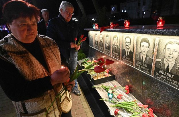 지난달 체르노빌 참사 33주년을 맞아 추모객들이 당시 희생된 이들의 영정 사진 앞에 꽃을 놓아 두고 있다.AFP 자료사진