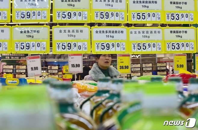 중국의 한 주부가 슈퍼마켓에서 가격표를 보고 놀란 표정을 짓고 있다. © 로이터=뉴스1