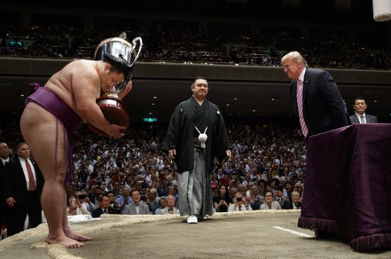 도널드 트럼프 미국 대통령(오른쪽)이 26일 오후 도쿄 스모경기장 고쿠기칸(國技館)에서 우승자인 아사노야마에게 '대통령 배(트로피)'를 수여한 후 허리 숙여 인사하고 있다. 외국 정상이 일본 스모 선수에게 직접 트로피를 수여하기는 이번이 처음이다. 도쿄=AP/뉴시스