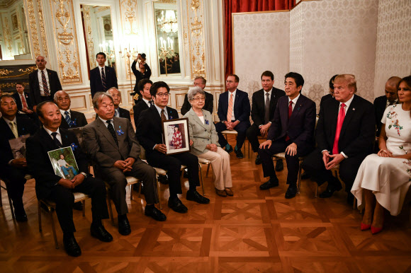 납치 피해자 가족 만난 트럼프… 아베, 조건 없는 북일회담 지지 요청  - 도널드 트럼프(오른쪽 두 번째) 미국 대통령과 부인 멜라니아(오른쪽)가 아베 신조(오른쪽 세 번째) 일본 총리와 함께 27일 도쿄 아카사카궁에서 북한에 납치된 일본인 피해자들의 가족, 친척들과 만나고 있다. 아베 총리는 일본인 납치 피해 문제를 해결하고자 김정은 북한 국무위원장과 전제 조건을 달지 않는 회담을 추진하겠다는 방침을 트럼프 대통령에게 전달하고 지지를 요청했다. 도쿄 AFP 연합뉴스