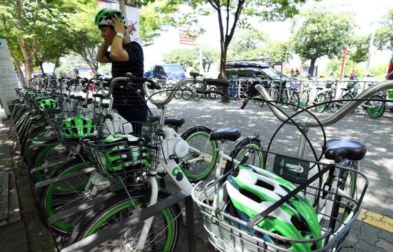 지난해 8월 한 시민이 서울 여의도 여의나루역에 설치된 ‘따릉이’ 대여소에서 안전모를 착용하고 있다. 서울시설공단은 자전거 헬멧 착용 의무화를 앞두고 2개월 간 헬멧 대여 서비스를 시범 운영했지만 저조한 실적 속에 후속 서비스는 제공하지 않고 있다. /사진=김범석 기자