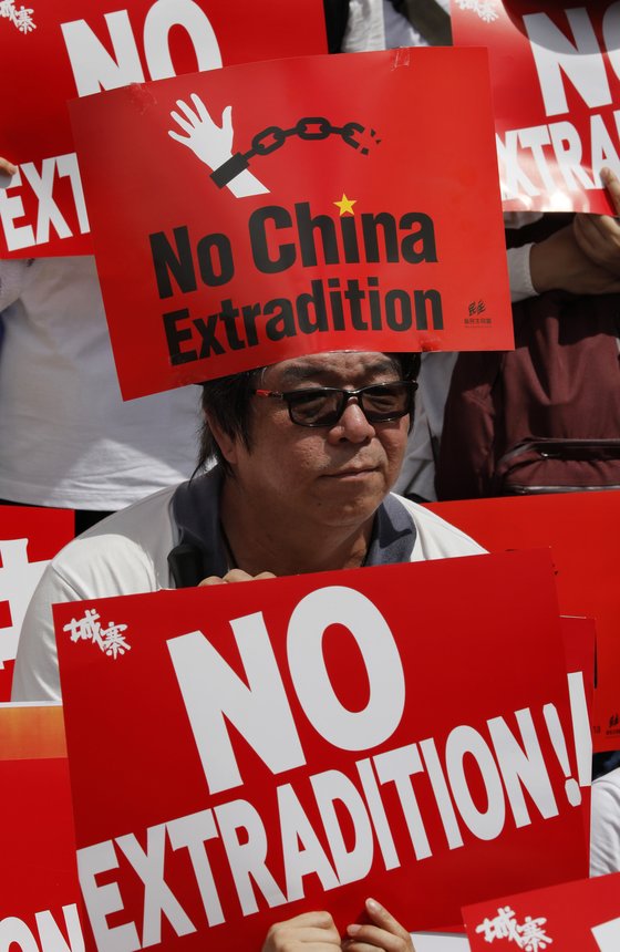 지난 9일(현지시간) 홍콩에서 벌어진 '범죄인 인도 법안' 반대 시위에서 한 남성이 '중국으로의 송환을 반대한다'는 팻말을 높이 들고 있다. [AP=연합뉴스]