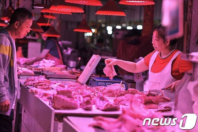 12일(현지시간) 중국 랴오닝성 선양의 한 시장에서 손님 한 명이 돼지고기를 사고 있다. 5월 중국의 돼지고기 가격은 18% 넘게 급등했다. © AFP=뉴스1