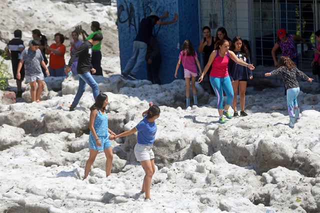 멕시코 과달라하라주 일부 지역에 비와 우박을 동반한 폭풍이 지나간 30일(현지시간) 지역 주민들이 눈처럼 쌓인 우박 위에서 놀고 있다.  로이터 연합뉴스