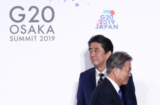 문재인 대통령(오른쪽)이 지난달 28일 오전 일본 오사카에서 열린 주요 20개국(G20) 정상회의 공식 환영식에서 의장국인 일본의 아베 신조 총리와 악수한 뒤 이동하고 있다. 오사카=연합뉴스
