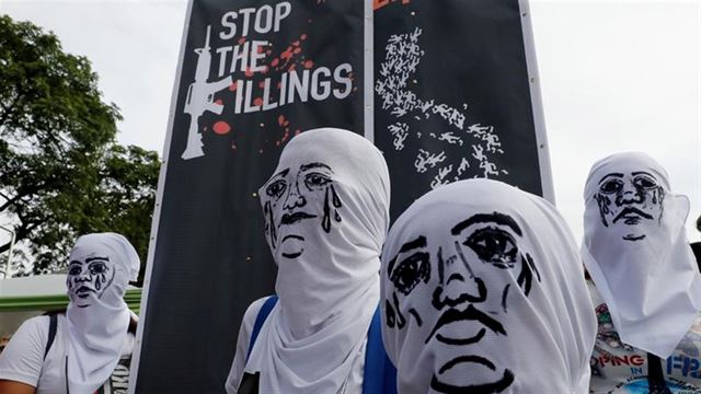 눈물 흘리는 얼굴을 그려넣은 하얀 천으로 본래 얼굴을 가린 필리핀 시위대가 마약과의 전쟁을 멈추라고 필리핀 정부에 촉구하는 모습. 로이터 연합뉴스