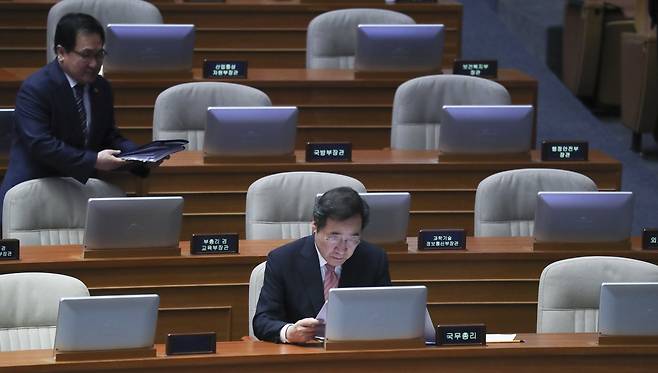 이낙연 국무총리(아래)가 10일 오후 국회 본회의장에서 경제 분야 대정부질문 전 자료를 살펴보고 있다. 유영민 과기부 장관이 조심스럽게 자리로 오고 있다. 임현동 기자