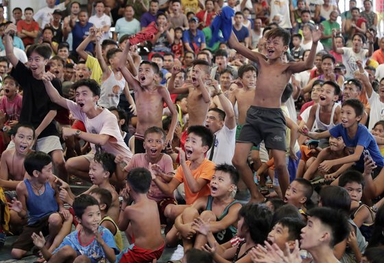 21일(현지시간) 필리핀 마닐라의 한 체육관에서 필리핀 시민들이 파퀴아오의 경기를 지켜보며 환호하고 있다.[AFP=연합뉴스]