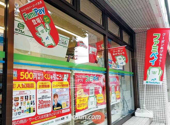 일본 도쿄 신주쿠의 패밀리마트 편의점 외부에 '파미페이(FamiPay)' 홍보물이 붙어 있다. 패밀리마트가 출시한 스마트폰 간편결제 서비스인 파미페이를 사용하는 고객에게 치킨 등 경품을 준다는 내용이다. /도쿄=최은경 특파원