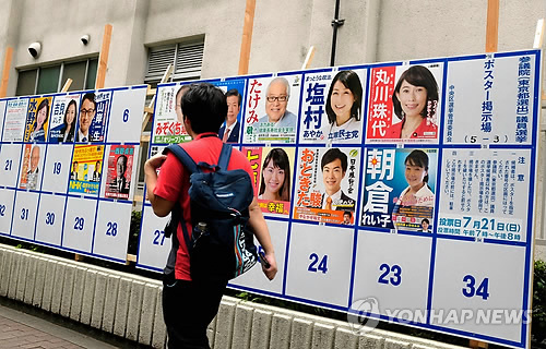 (도쿄 AFP=연합뉴스) 아베 신조(安倍晋三) 총리 정권의 중간평가 성격을 띠는 일본 참의원(상원 해당) 선거일인 21일 도쿄에서 한 남성이 선거벽보 옆을 지나고 있다. bulls@yna.co.kr