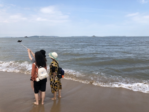 대만 진먼다오 마주보는 중국 샤먼 해변 (샤먼=연합뉴스) 차대운 특파원 = 지난 19일 중국 관광객들이 푸젠성 샤먼(廈門)시에 있는 '일국양제(一國兩制) 해변'에서 바다 건너편에 있는 대만의 진먼다오(金門島)를 바라보며 사진을 찍고 있다. 2019.7.22  cha@yna.co.kr  (끝)