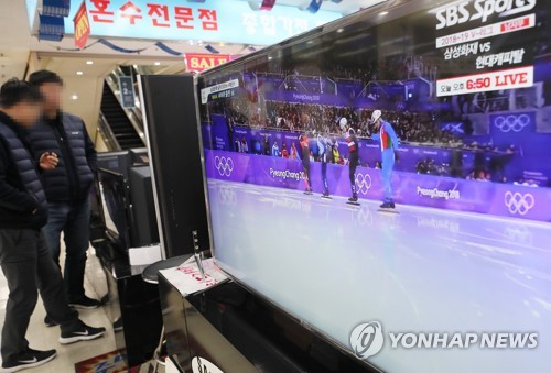 대형 TV 판매장에서 방문객들이 스포츠 경기를 관람하고 있다. [연합뉴스]