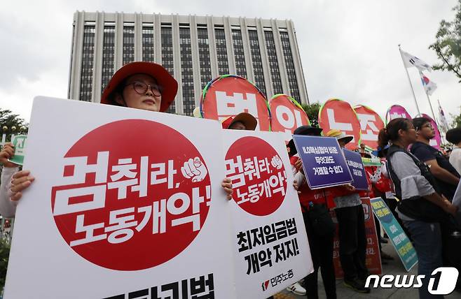 민주노총 노조원들이 30일 오후 종로구 세종대로 정부서울청사 앞에서 '고용노동부 ILO 핵심협약 관련 법 개악 발표에 대한 규탄 기자회견'을 갖고 구호를 외치고 있다. 2019.7.30/뉴스1 © News1 박세연 기자