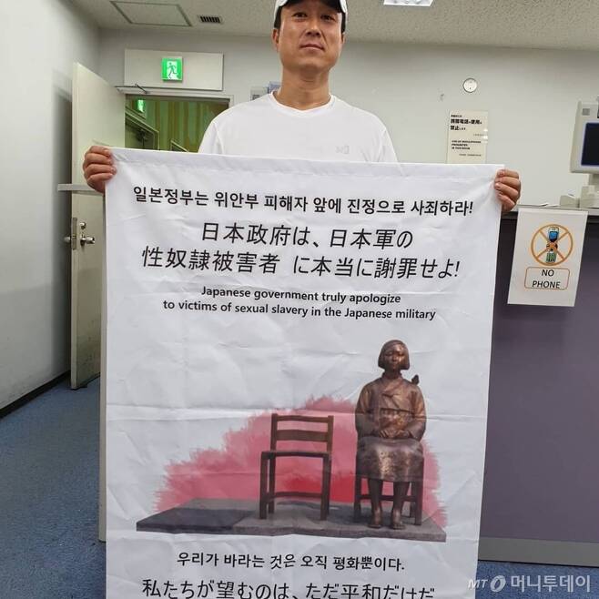 서영근씨(44)가 지난 12일 오전 10시30분 일본 도쿄 나리타공항 출입국사무소에서 현수막을 들고 있다. /사진=서영근씨 제공