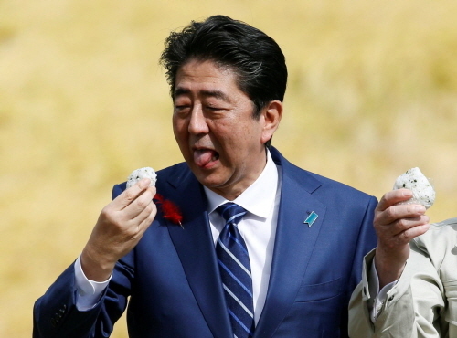 후쿠시마현산 쌀로 만든 주먹밥. 아베 총리가 맛있게 시식하고 있다. 사진=마이니치신문 캡처