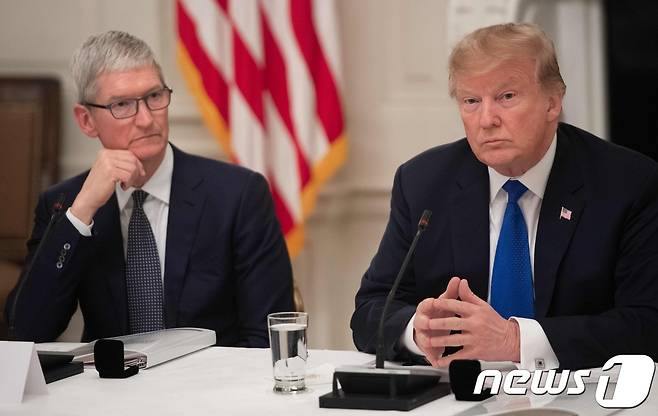 팀 쿡 애플 최고경영자(CEO)가 지난 16일(현지시간) 도널드 트럼프 미국 대통령을 만나 "애플은 관세를 부과받는데, 삼성은 내지 않는다"고 하소연한 것으로 알려졌다. (Photo by SAUL LOEB / AFP)