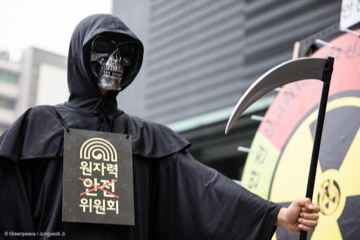 2016년 5월 26일 원자력안전위원회가 위치한 서울 종로구 KT빌딩 앞에서 ‘죽음의 신’으로 분장한 그린피스 운동가가 ‘안전 복불복’이라고 이름 붙은 대형 돌림판을 앞에서 원전 반대 퍼포먼스를 하고 있다. 그린피스 제공