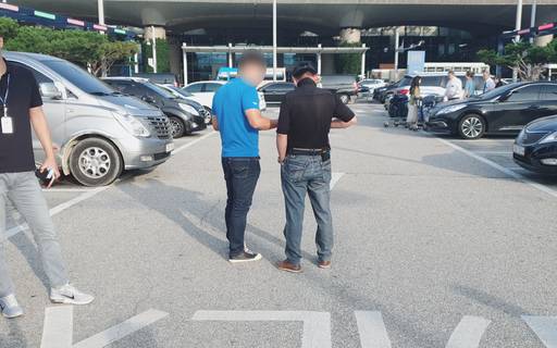 한 남성이 지난 19일 인천국제공항 단기주차장에서 불법주차대행 영업을 하다 경찰에 적발돼 조사를 받고 있다.