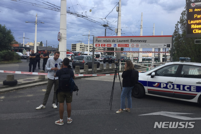 【빌뢰르만( 프,랑스)= AP/뉴시스】 경찰이 금지선을 쳐 놓은 프랑스 리옹 교외 빌뢰르반 지하철 역에서 31일 보도진들이  흉기사건에 대해서 취재를 하고 있다.  30대 남성이 휘두른 칼에 1명이 숨지고 9명이 다쳤으며 그 중 3명은 위독하다고 경찰은 밝혔다.