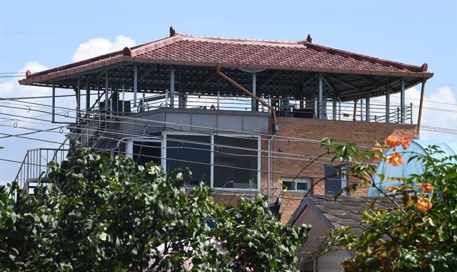 상가 옥상 위에 설치된 한옥 형태의 지붕 모습.