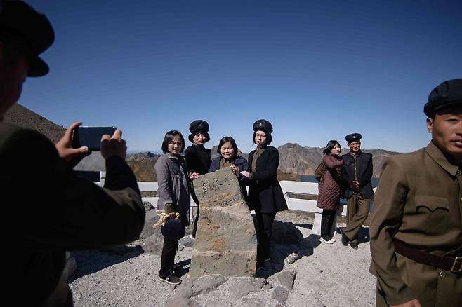 지난 11일 삼지연 백두산 정상부근 전망대에 오른 북한 학생들이 기념촬영을 하고 있다. [AFP=연합뉴스]