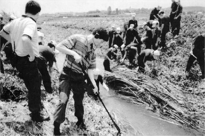 93년 7월 화성연쇄살인사건 수사본부가 화성군 정남면 관항리 인근 농수로에서 유류품을 찾고 있는 모습. 사진=연합뉴스