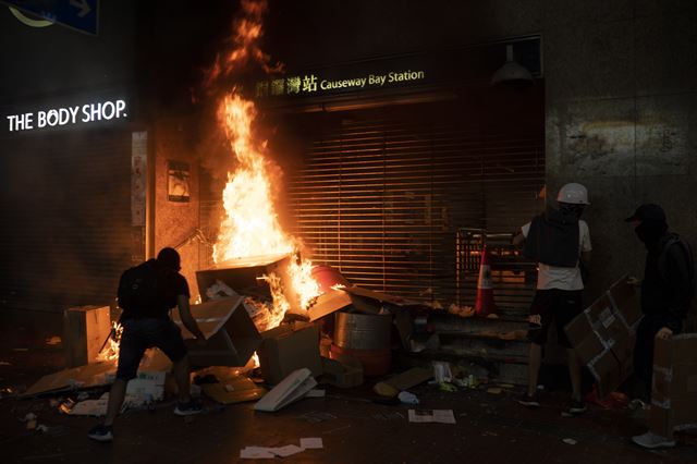 홍콩 반정부 시위대가 4일 밤 코즈웨이베이 지하철역 입구에 불을 지르고 있다. 이날 홍콩 지하철 역사 곳곳에서 방화가 속출했다. 홍콩=AP 연합뉴스