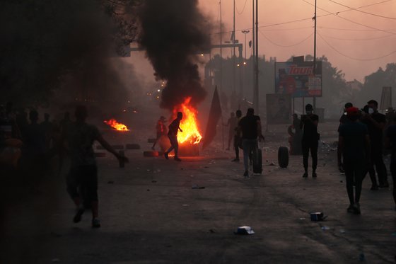5일 반정부시위대가 바그다드 시내 도로에 불을 질렀다. 이라크 경비대가 발포한 실탄에 수십 명의 시위대가 사망했다. [AP=연합]