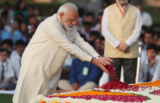나렌드라 모디 인도 총리가 지난 2일 마하트마 간디 탄생 150주년을 맞아 열린 기념행사에서 꽃을 뿌리고 있다.[로이터=연합뉴스]