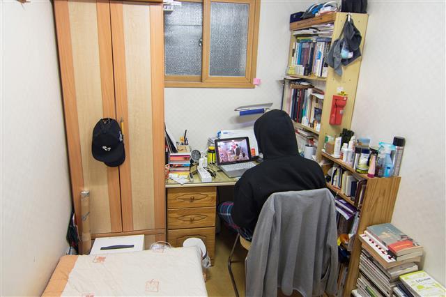 한 직장인이 6.6㎡의 고시원에서 일하고 있는 모습.서울신문 DB