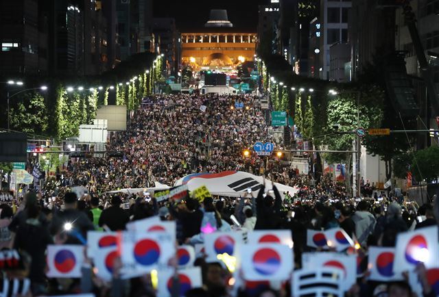 '제9차 사법적폐 청산을 위한 검찰 개혁 촛불 문화제' 참가자들이 12일 서울 서초구 서초역에서 예술의전당으로 이어지는 반포대로 위에서 태극기 퍼포먼스를 펼치고 있다. 연합뉴스