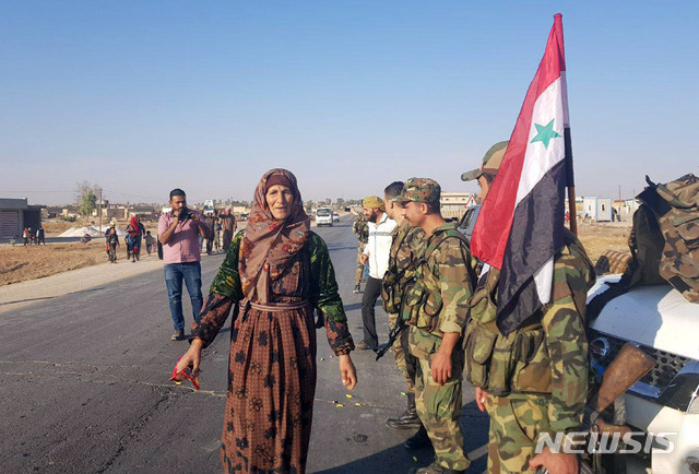 시리아 관영 통신이 제공한 사진으로 동부의 14일 탈 탐르 주민이 입성한 시리아 정부군을 환영하고 있다    AP