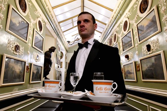 나비 넥타이를 한 카페 그레코의 웨이터가 2018년 1월 손님에게 커피를 서비스하고 있다. [AFP=연합뉴스]