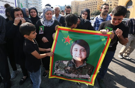 지난 13일(현지시간) 레바논에 거주하는 쿠르드인들이 터키 용병의 손에 잔혹하게 살해당한 헤브린 칼라프 미래시리아당 사무국장의 사진을 들고 터키의 군사작전을 비난하는 시위를 벌이고 있다. [로이터=연합뉴스]