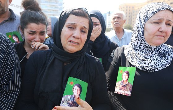 지난 13일(현지시간) 레바논에 거주하는 쿠르드 여성들이 터키 용병의 손에 잔혹하게 살해당한 칼라프의 사진을 들고 터키의 군사작전을 비난하는 시위에 참석하고 있다. [로이터=연합뉴스]
