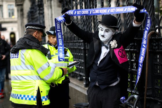 찰리 채플린으로 분장한 시위대가 영국 의회 밖에서 시위 중 체포되고 있다. [로이터=연합뉴스]