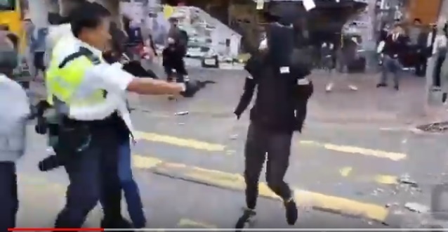 【서울=뉴시스】 홍콩 사이완호 지역에서 11일 오전 경찰 한 명이 검은색 옷을 입고 얼굴을 가린채 다가오는 시위 참가자를 향해 총을 쏘고 있다. 이 사람은 실탄에 맞아 부상을 입은 것으로 전해지고 있다. 사진은 유튜브 동영상을 캡처한 것이다. <사진출처: 유튜브> 2019.11.11