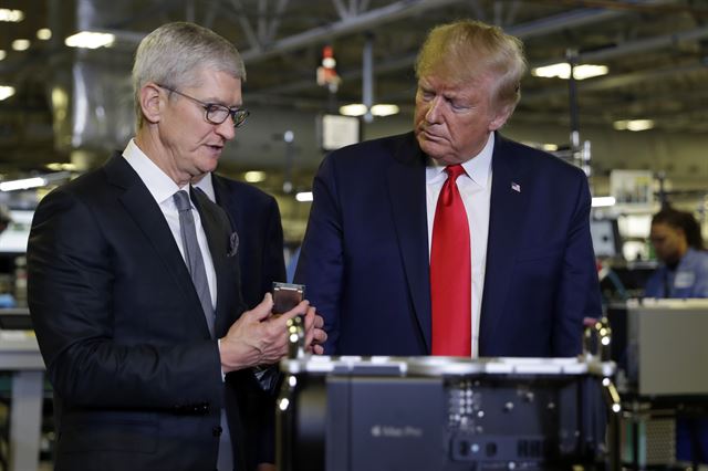 도널드 트럼프(오른쪽) 미국 대통령이 20일 팀 쿡 애플 최고경영자와 함께 텍사스 오스틴에 있는 애플 생산 공장을 둘러보고 있다. 텍사스=AP 연합뉴스