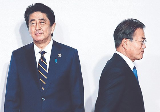 문재인 대통령이 지난 6월 28일 일본 오사카에서 열린 G20 정상회의 환영식에서 아베 신조 일본 총리(왼쪽)와 8초간 악수한 뒤 이동하고 있다. [청와대사진기자단]