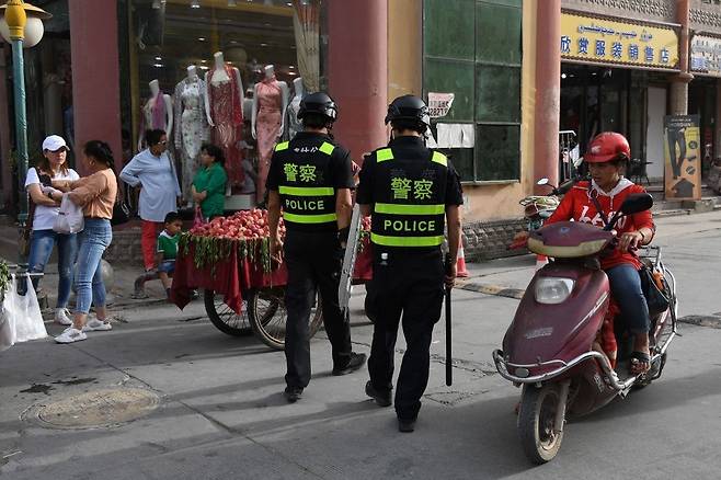 2017년 중국 서부 신장 위구르 자치구의 오아이스 도시 카슈가르슈 거리를 중국 공안경찰이 순찰하고 있다. ICIJ 누리집