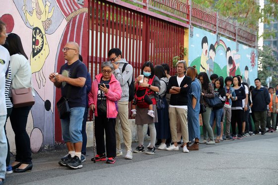 24일 치러진 홍콩 구의원 선거는 홍콩 반환 이후 최대인 294만 명의 유권자가 투표했다. 사진은 투표소에 길게 줄을 서있는 홍콩 유권자들. [로이터=연합뉴스]