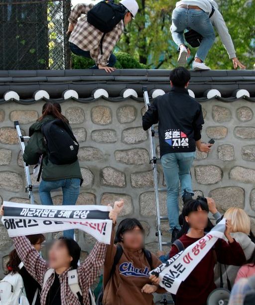 한국대학생진보연합이 10월18일 오후 서울 중구 주한 미국대사관저에서 방위비분담금 협상 관련 기습 농성을 하기 위해 담벼락을 넘고 있다. 뉴시스