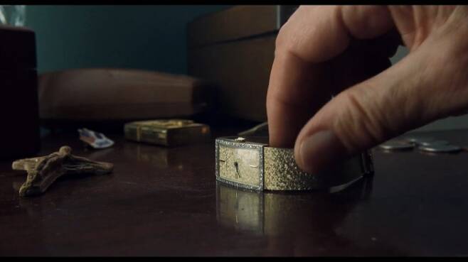 로버트 드니로가 탁자 위에 있는 자신의 시계 매티 티쏘를 착용하는 장면 [사진=영화 '아이리시맨' 캡처]