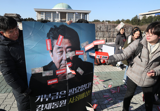 아베규탄시민행동 회원들이 지난 5일 서울 여의도 국회 앞에서 '아베 면죄부 주는 문희상 안 규탄한다' 기자회견을 열고 기부금은 필요 없다는 내용의 모조 돈 뿌리기 퍼포먼스를 하고 있다. 뉴시스