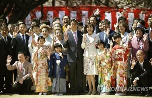 아베 신조 총리 부부가 2019년 4월 13일 도쿄 '신주쿠 교엔'에서 열린 '벚꽃을 보는 모임' 행사에서 기념사진 촬영에 응하고 있다. [교도=연합뉴스 자료사진]
