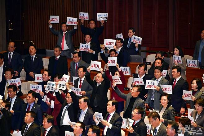 자유한국당 의원들이 10일 저녁 국회 본회의에서 내년도 정부 예산안 수정안이 상정되자 '날치기' 피켓을 들고 반발하고 있다. 윤창원기자
